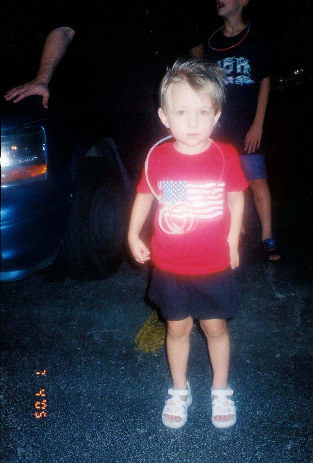a little boy wearing an american flag t - shirt