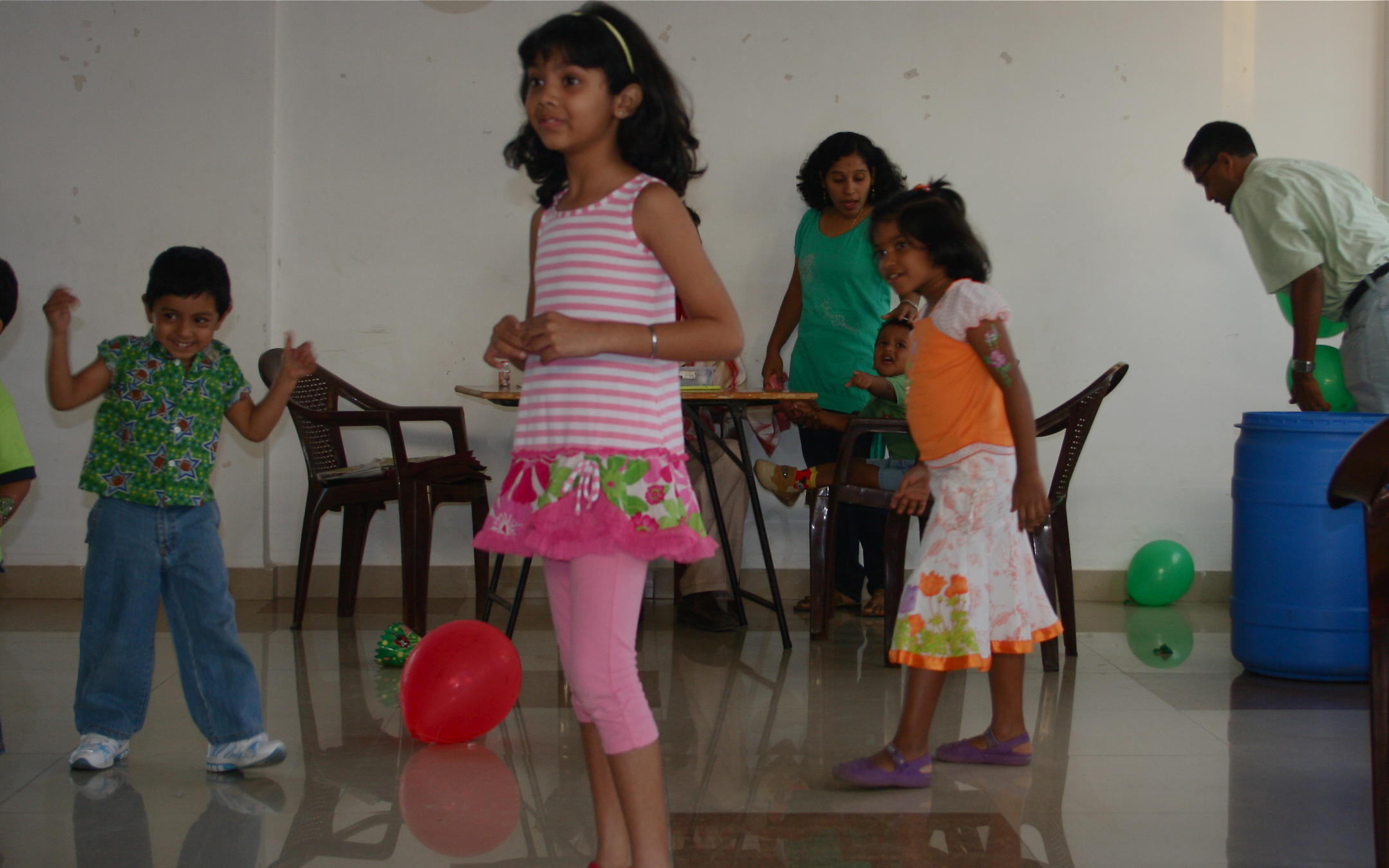 some little girls playing with a red ball in the middle
