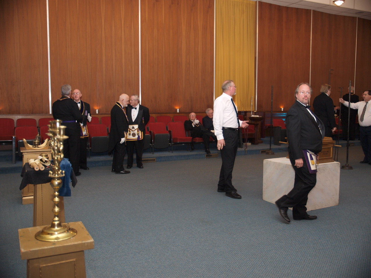 the men are standing in formal wear in a room