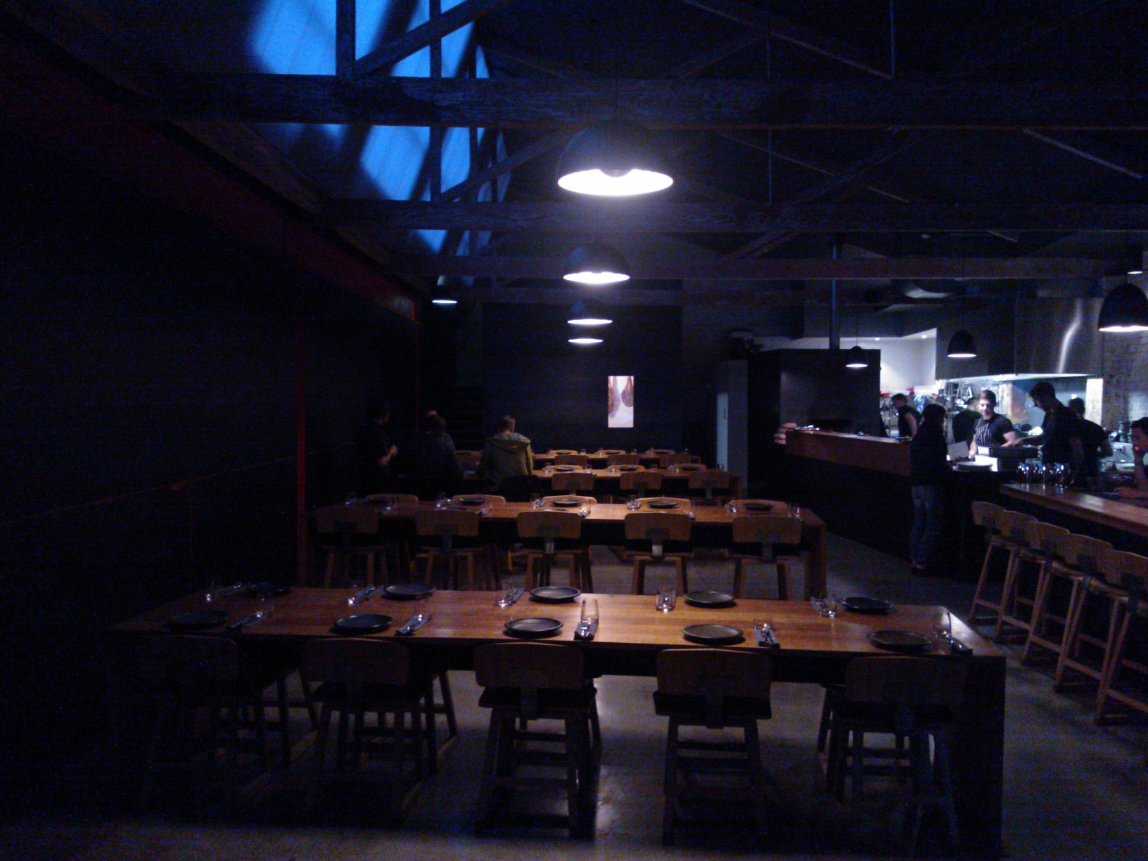 several wooden tables in a bar with patrons