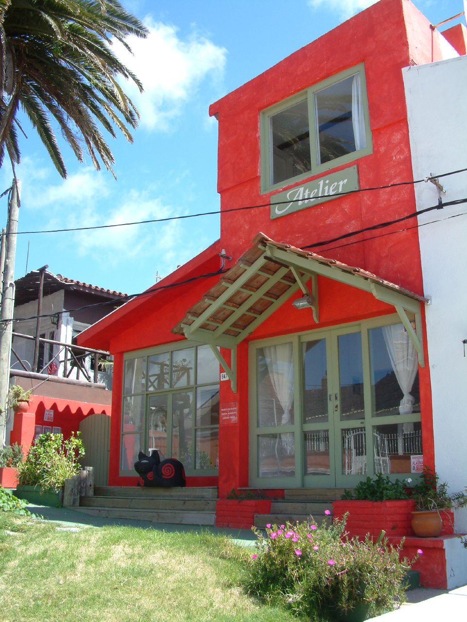 a red building has a white roof and a wooden porch