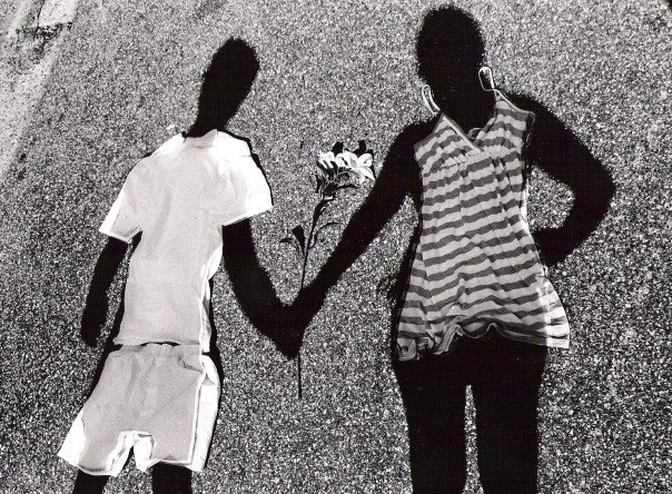 two people are holding hands on the side of a road