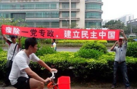 man on a bike holding up his arm to celete in an asian country