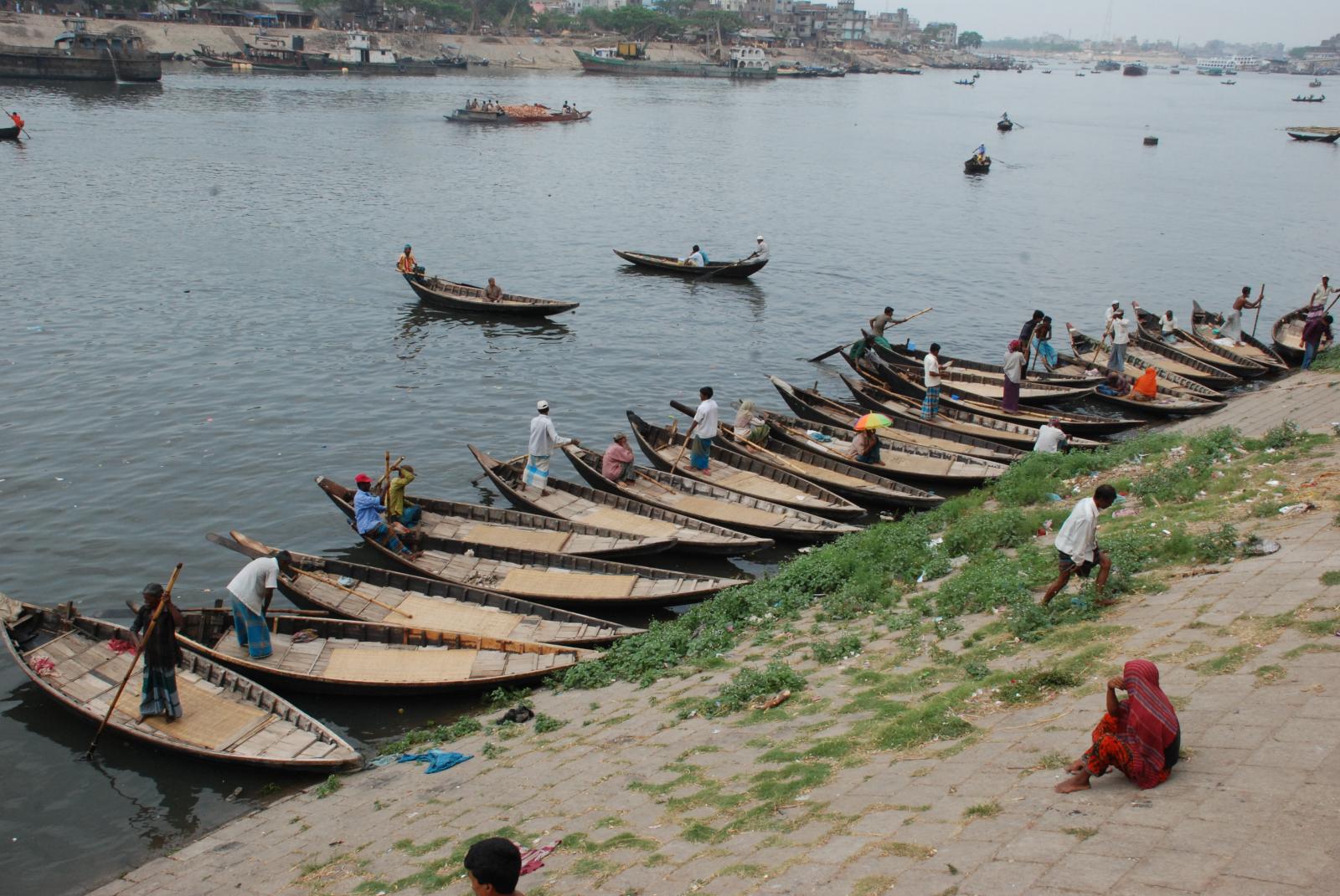 a group of canoes sit on the shore of a river