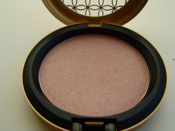 an open pink powder face palette sits on the table