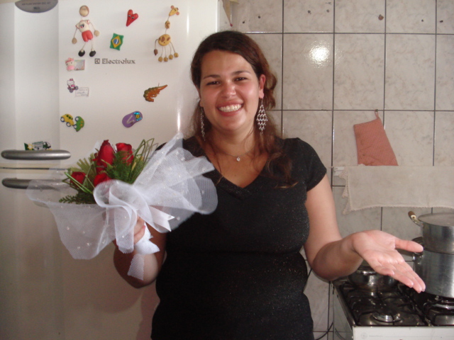 a woman in a kitchen holding up a bouquet