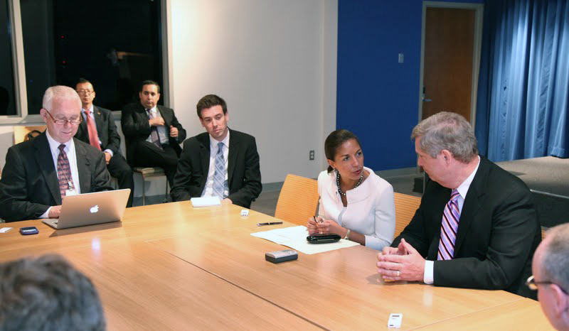 several business people sitting around a wooden table