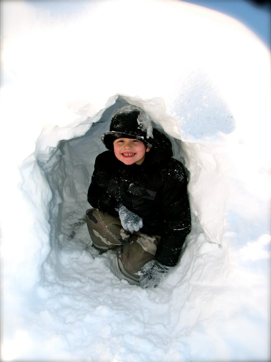 a little boy that is sitting in some snow