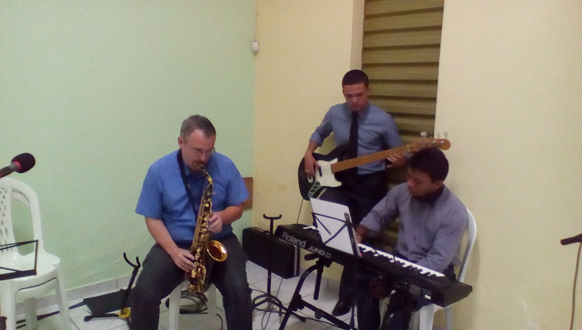 a trio of musicians in an empty space with instruments