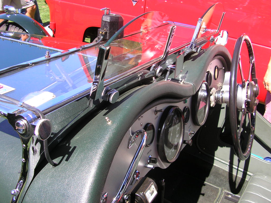 the dashboard in a military jeep, with another vehicle at the back