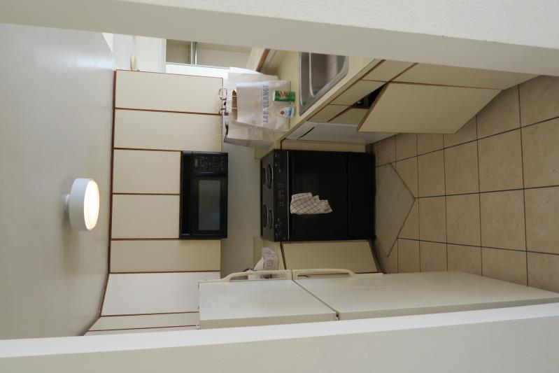 this kitchen is clean and has a white tile floor