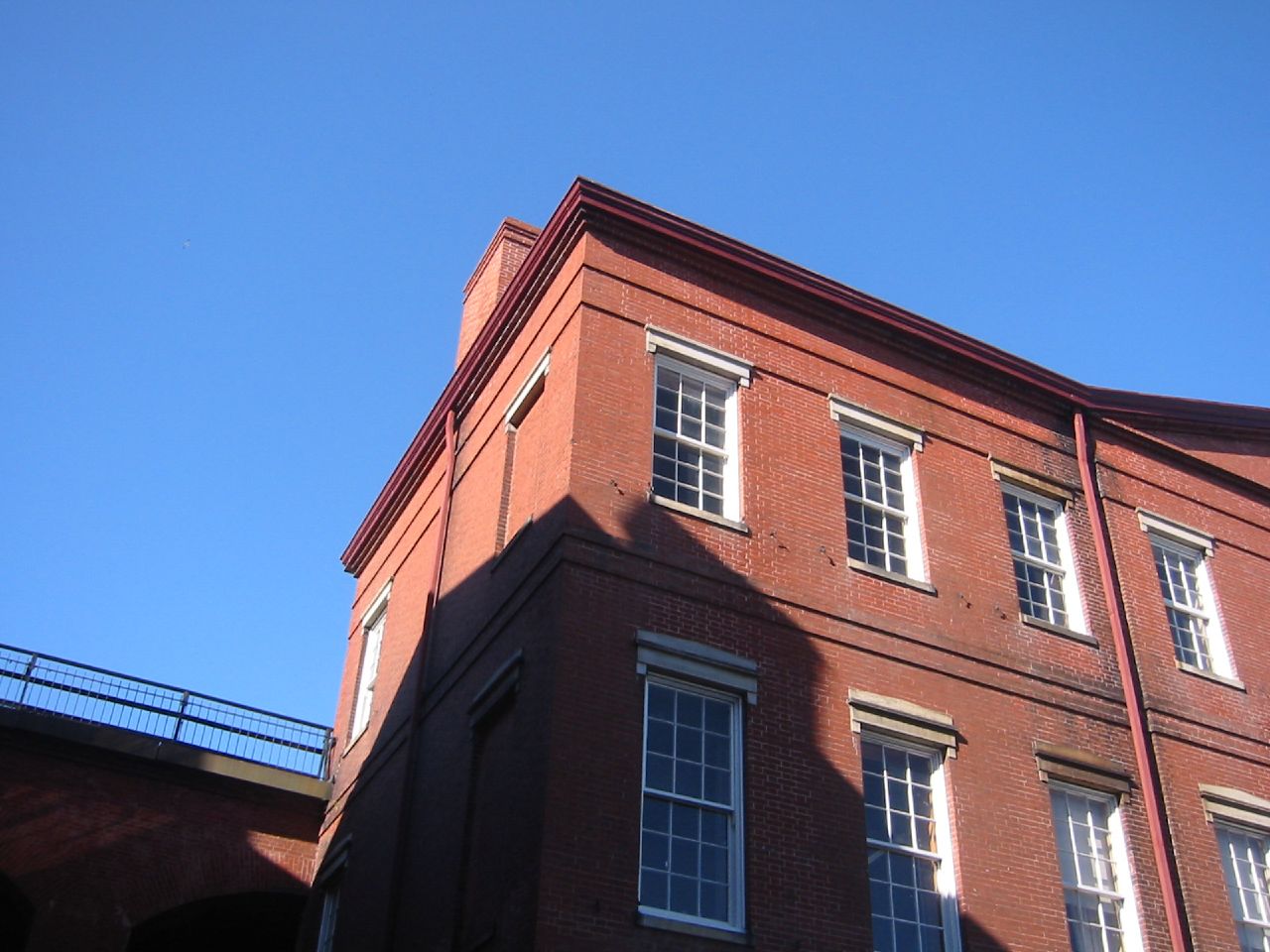 there is a red brick building with windows on the corner