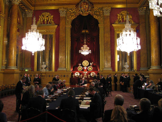 people sitting at tables in a large hall