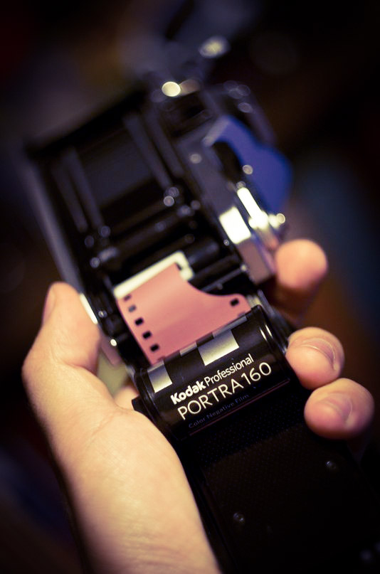 the hand of a person holding a small camera