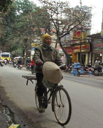 a man riding a bicycle with a large ball on the back