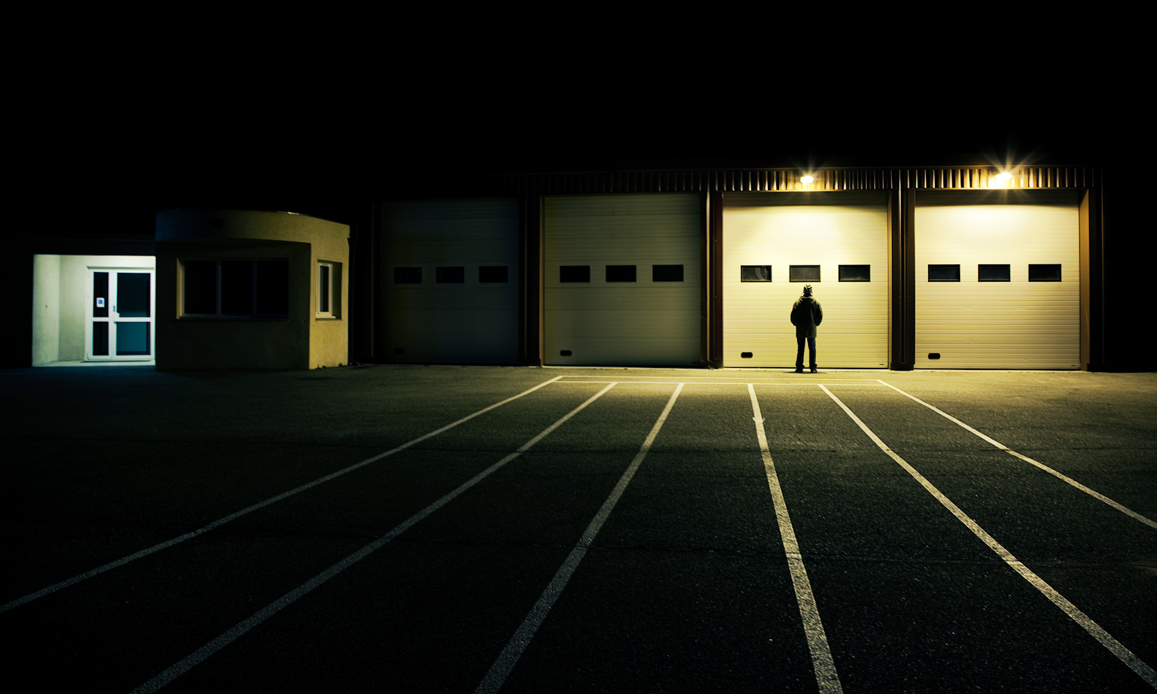 a man standing in front of a building at night