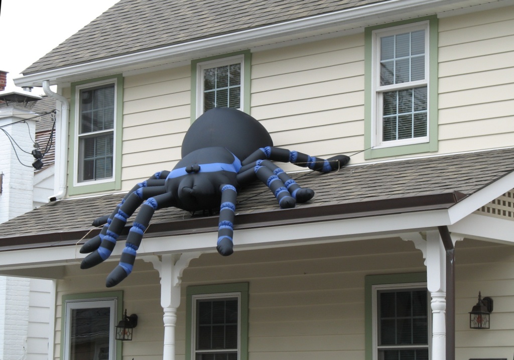 a large spider sculpture sitting on top of a white house