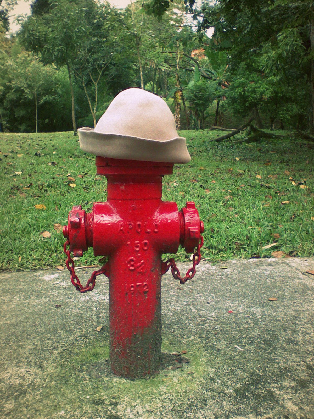 the red fire hydrant has a hat on it's top