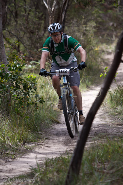 man riding bike down a trail in the woods