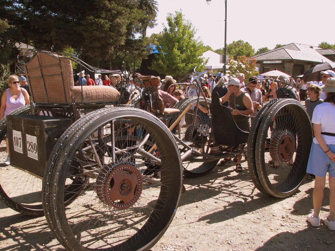 a group of people standing next to an antique car