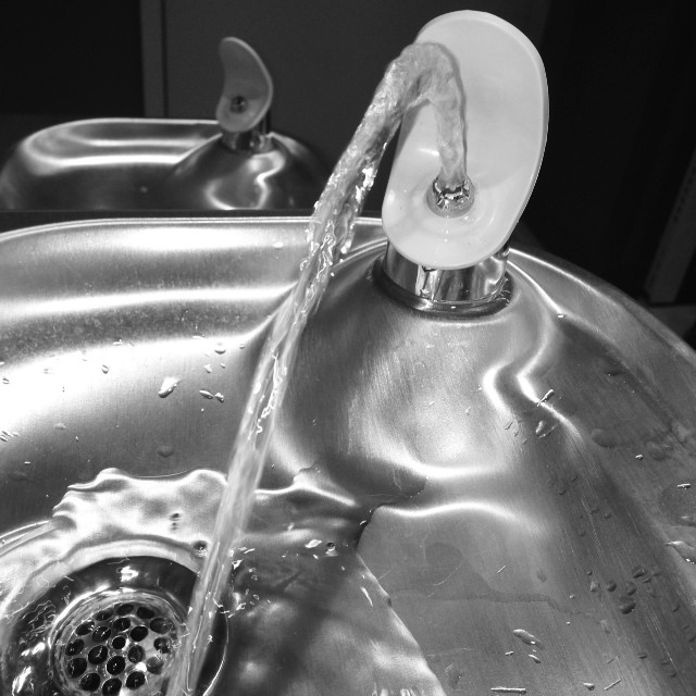 a silver sink filled with water running from the faucet