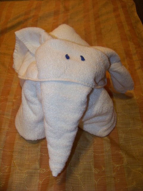 an elephant towel wrapped around on top of a bed