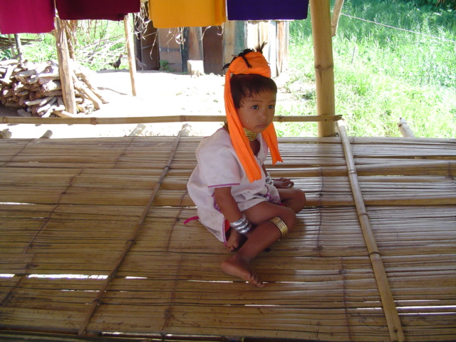 a little child that is sitting down on bamboo