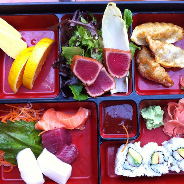 a close up of a tray of food with sushi