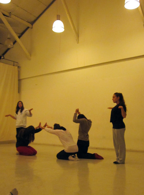 several people sitting on the ground while performing an exercise in an indoor space