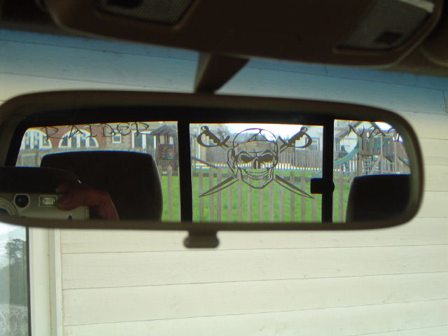 a side view mirror on a car with a man in the background