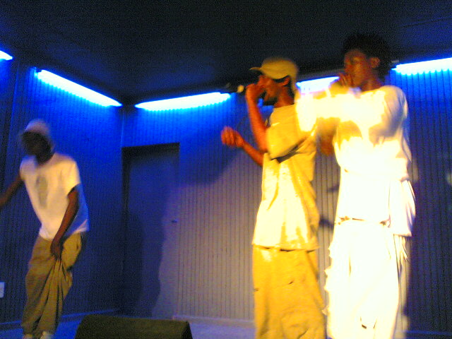 men stand in a room on stage dressed in white