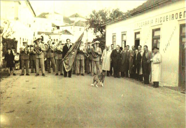 old pograph of men in front of white building with dog