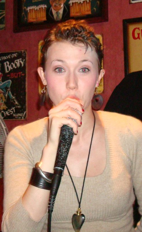 a woman holding a microphone and making a funny face