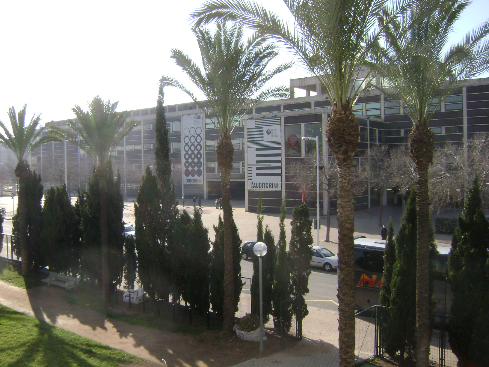 there is a large building behind many palm trees