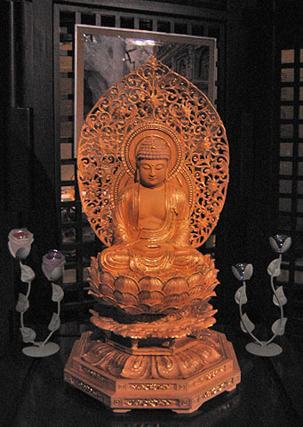 a wooden statue sitting in front of an image