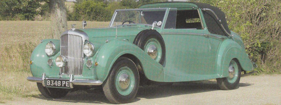 an old fashioned vehicle parked in the grass