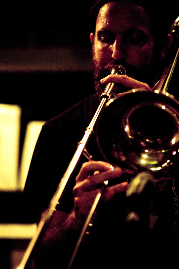 a man in a dark shirt playing a trombone