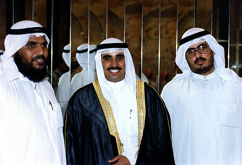 three men in white standing together in front of a wall