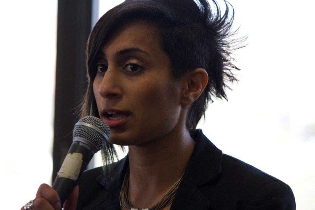 a woman standing with a microphone at her side