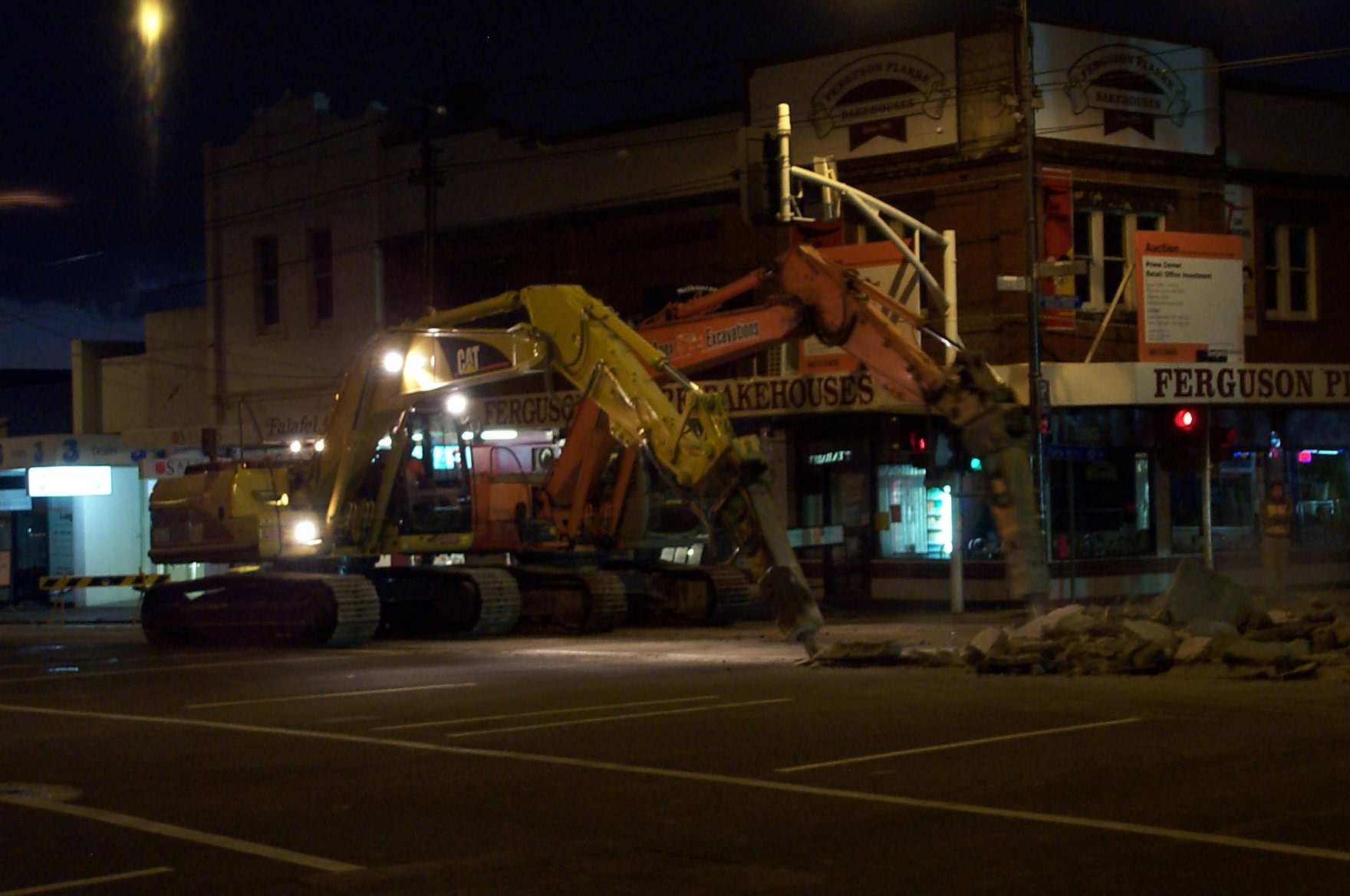 construction equipment parked in front of a building at night