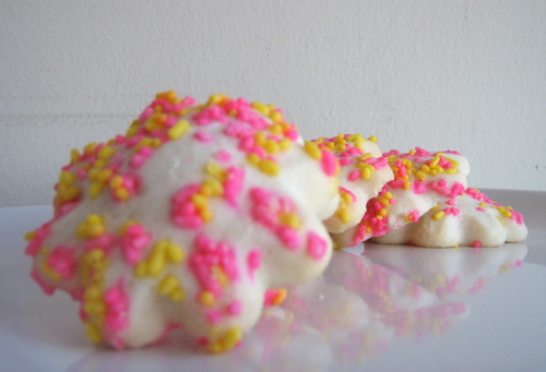 an assortment of white, pink, and yellow treats on the counter