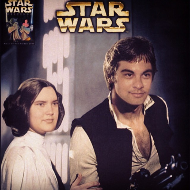 a man in a vest and a woman in star wars clothes are facing each other