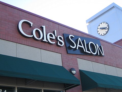 the front of cole's salon showing a clock on its tower