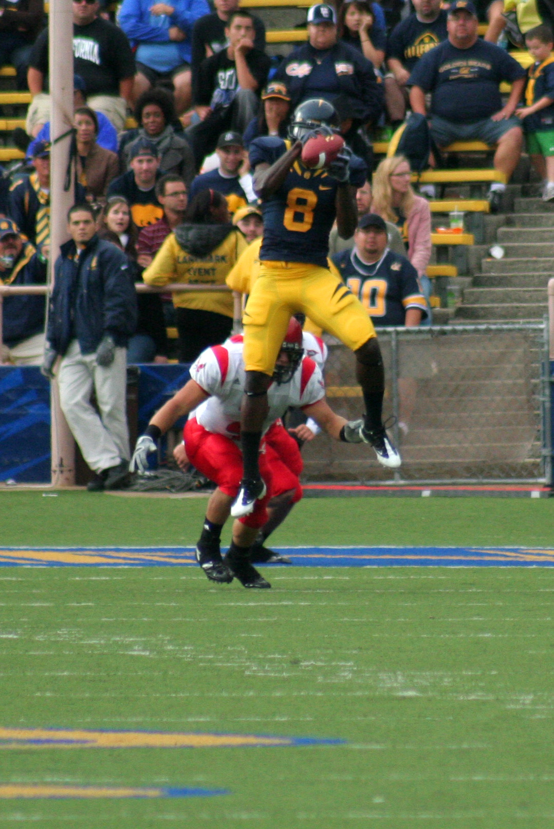 two football players jumping up to the ball in a game