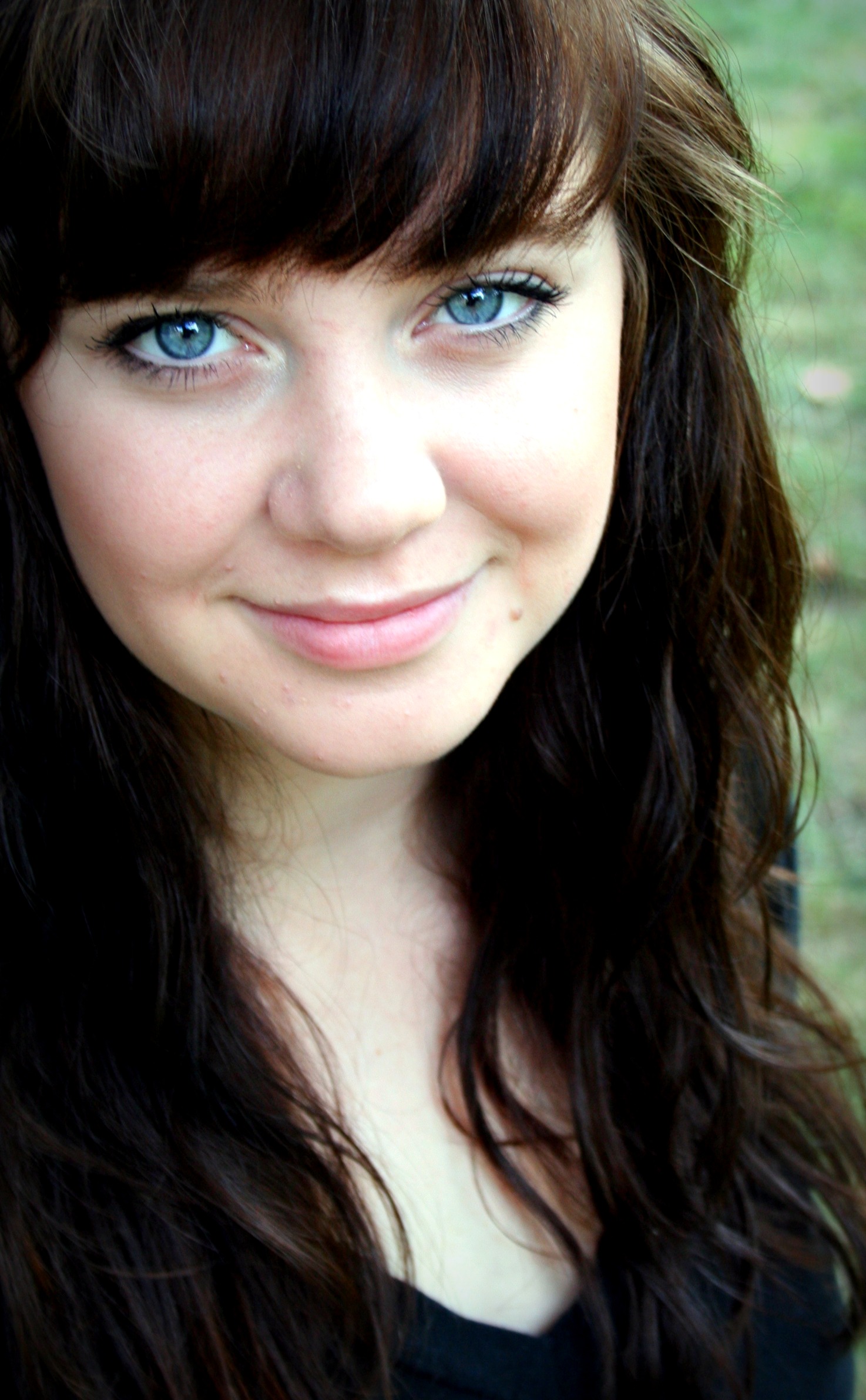 a young lady has blue eyes and long brown hair