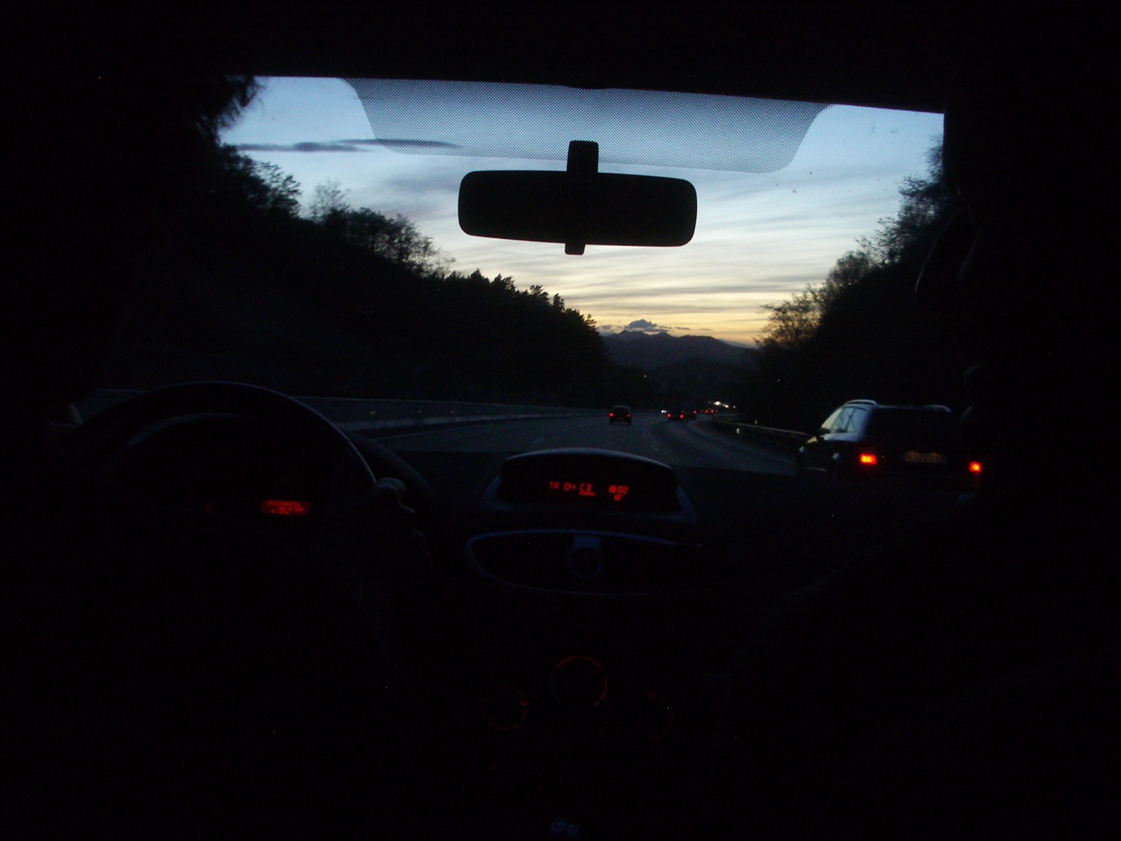 the view from the inside of a car driving down a road at night