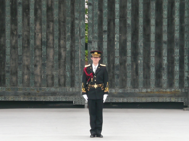 a man in uniform standing near a metal fence