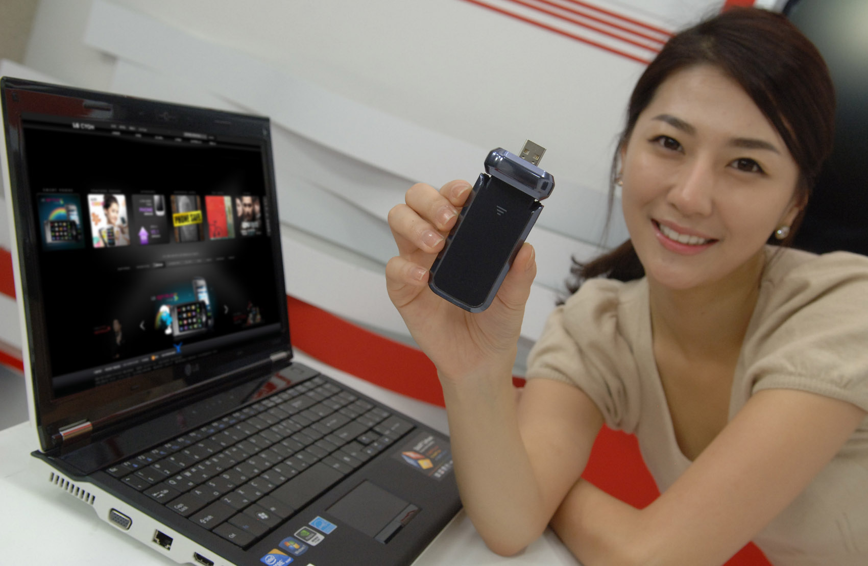 a woman holding an open laptop computer next to her