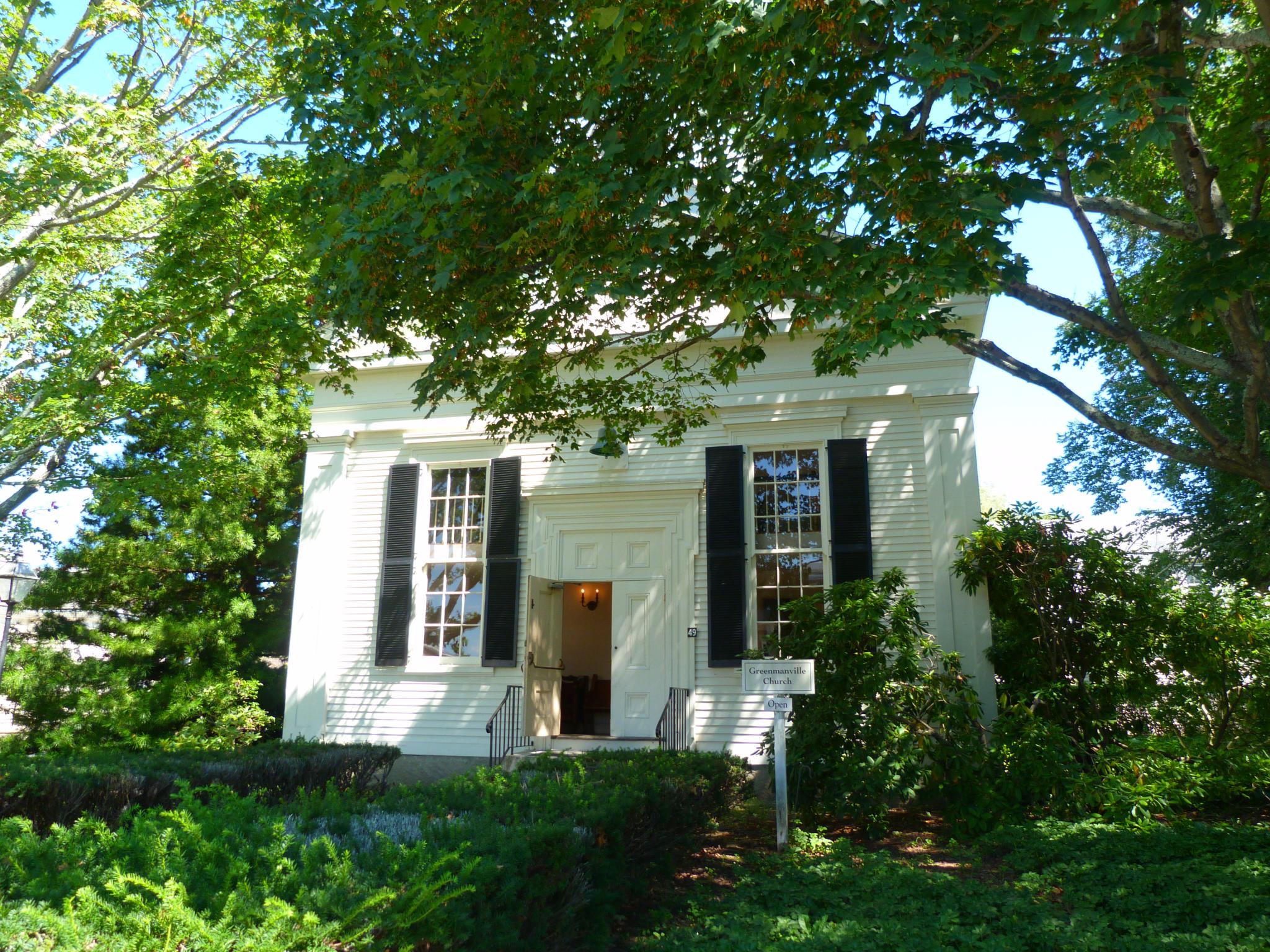 the building has three windows and black shutters