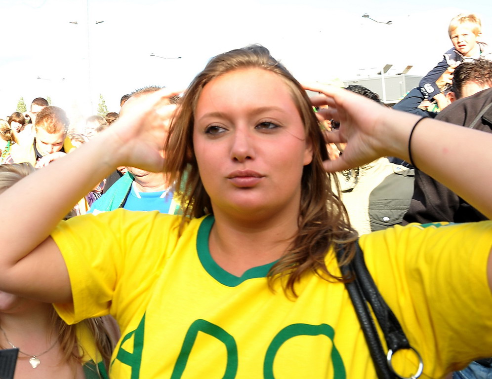 a women in soccer shirt holding her hands on top of her head